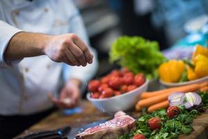 Chef putting salt on juicy slice of raw steak photo