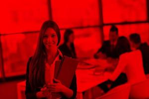 business woman with her staff in background at office photo