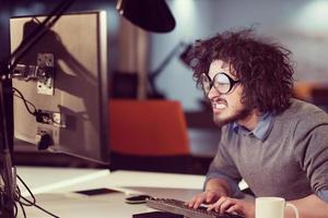 hombre trabajando en una computadora en una oficina de inicio oscura foto