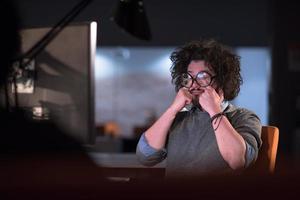 hombre trabajando en una computadora en una oficina de inicio oscura foto