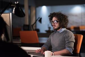 man working on computer in dark startup office photo
