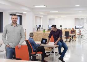 startup business, businessman portrait at modern office, team brainstorming in background photo