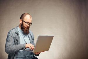 lifestyle successful freelancer man with beard achieves new goal with laptop in loft interior. photo