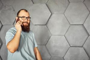 bearded man with glasses talking on a mobile phone photo