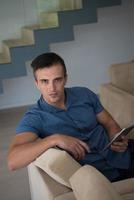 young man using a tablet at home photo