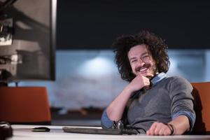 hombre trabajando en una computadora en una oficina de inicio oscura foto