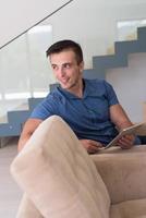 young man using a tablet at home photo