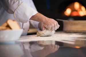 chef hands preparing dough for pizza photo