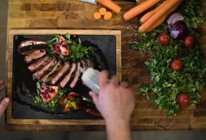 top view of Chef finishing steak meat plate photo