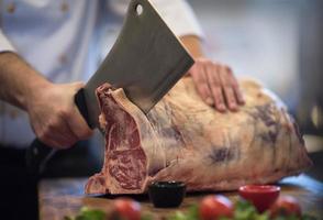 chef cutting big piece of beef photo