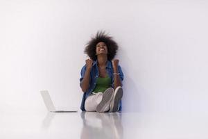 african american woman sitting on floor with laptop photo