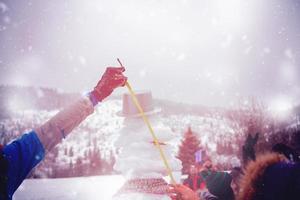 jóvenes midiendo la altura del muñeco de nieve terminado foto