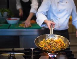 chef flipping vegetables in wok photo