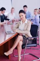 business woman with her staff in background at office photo