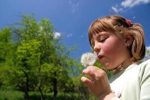 cute girl blowing dundelion photo