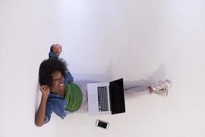 african american woman sitting on floor with laptop top view photo