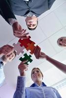 Group of business people assembling jigsaw puzzle photo