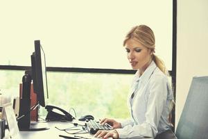 mujer de negocios trabajando en su escritorio en una oficina foto