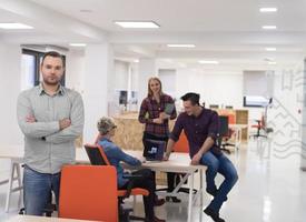 startup business, businessman portrait at modern office, team brainstorming in background photo