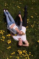 man and woman lying on the grass photo