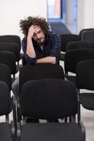 A student sits alone  in a classroom photo