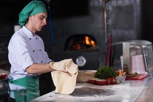 chef preparing dough for pizza photo