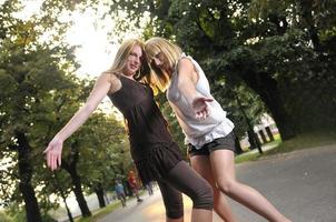 two girls together outside in dancing position ready for party photo