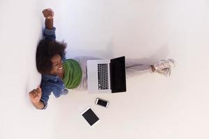 african american woman sitting on floor with laptop top view photo