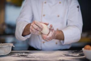 chef hands preparing dough for pizza photo