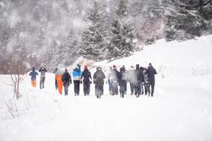 grupo de jóvenes caminando por un hermoso paisaje invernal foto