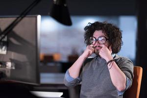 hombre trabajando en una computadora en una oficina de inicio oscura foto