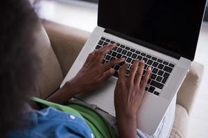 African American women at home in the chair using a laptop photo