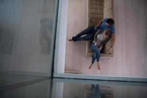 pareja joven en la sala de estar con vista superior de la tableta foto