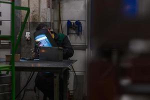 Professional welder performs work with metal parts in factory, sparks and electricity. Industry worker banner. photo