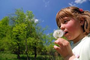 cute girl blowing dundelion photo