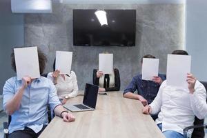 startup business team holding a white paper over face photo