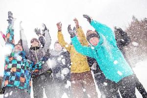 grupo de jóvenes tirando nieve al aire foto