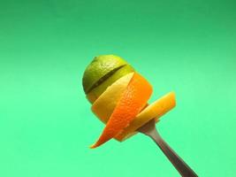 Rodajas de naranja y limón en tenedor foto