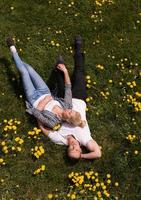 man and woman lying on the grass photo