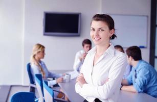 business woman with her staff in background at office photo