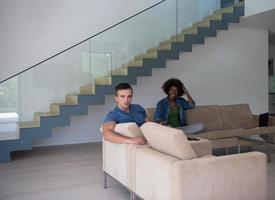 young multiethnic couple relaxes in the living room photo