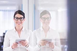 mujer de negocios usando tableta digital frente a la oficina de inicio foto