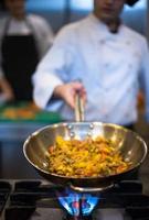 chef flipping vegetables in wok photo