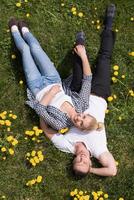 man and woman lying on the grass photo