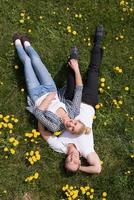 man and woman lying on the grass photo