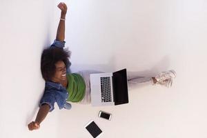 african american woman sitting on floor with laptop top view photo