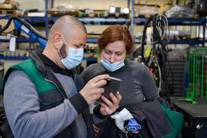 Industrial workers with face masks protected against corona virus discussing about production in factory. People working during COVID-19 pandemic. photo