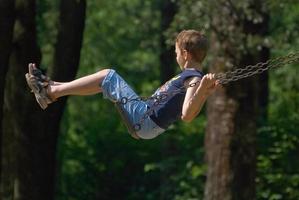 boy swinging in park photo