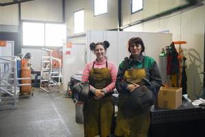 retrato de dos soldadores sosteniendo máscaras de soldadura en sus manos y preparándose para el trabajo duro en una fábrica