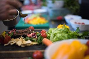 Chef hand finishing steak meat plate photo